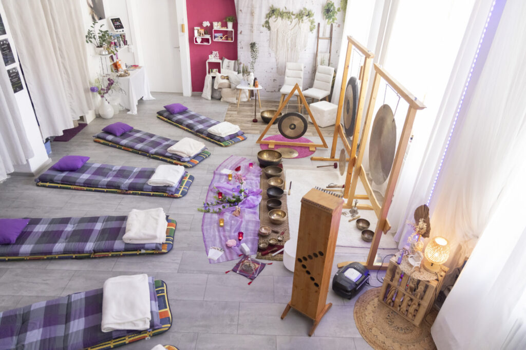 Studio mit aufgebauten Klangschalen und Entspannungsliegen